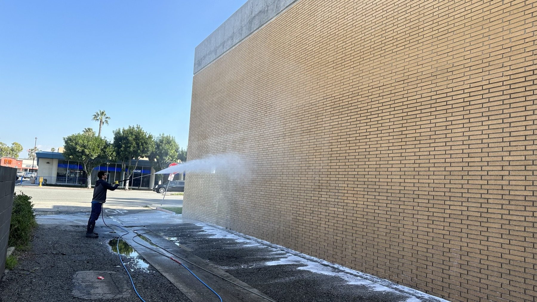 A soiled brick elevation being washed down